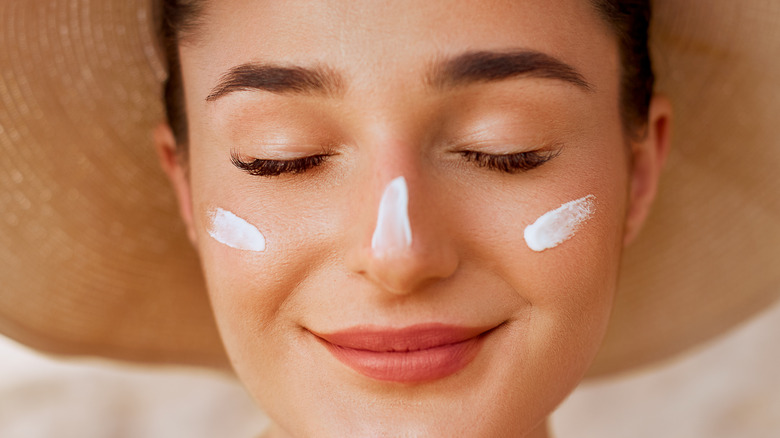 Woman with stripes of sunscreen on her face