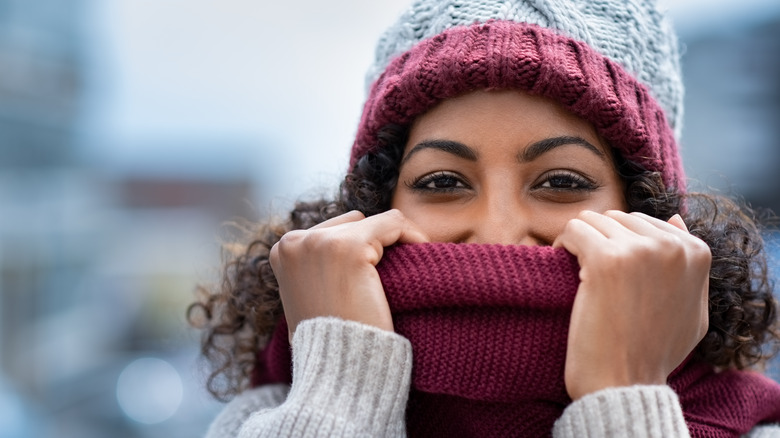 woman hiding under knit scarf