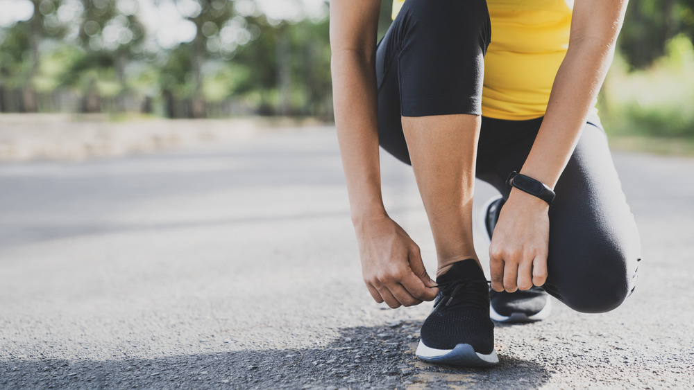 Runner crouching and tying sneaker