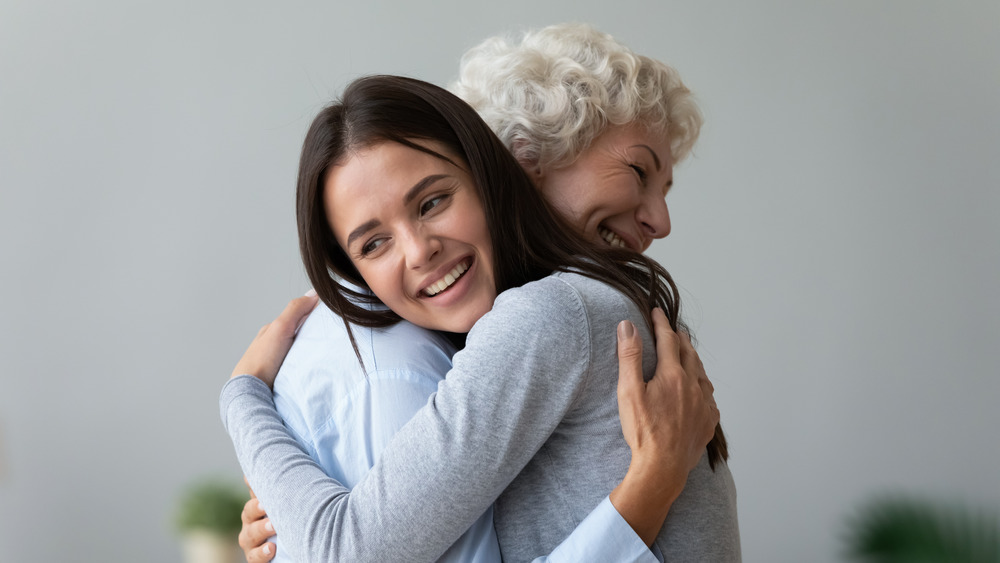Older woman hugging younger woman 