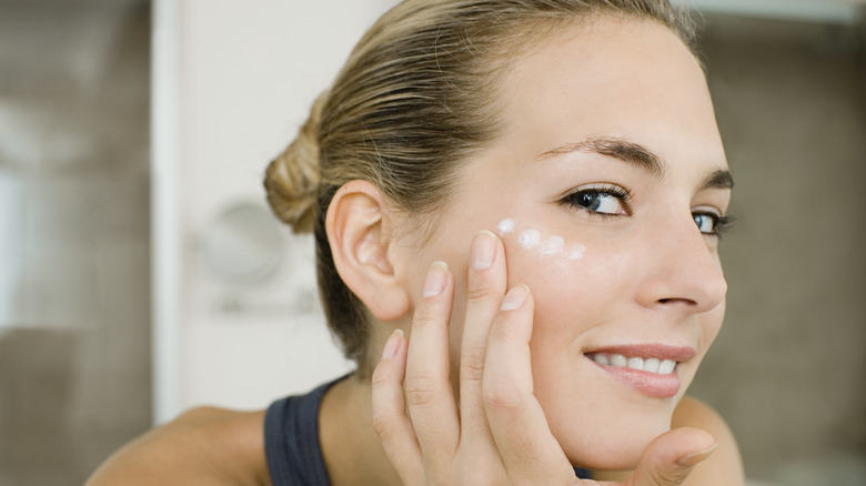 Woman looking at her face in the mirror