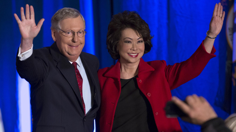 Mitch McConnell and Elaine Chao smiling and waving