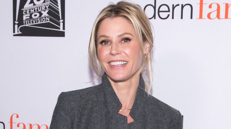 Julie Bowen smiling in a grey blazer at a Modern Family event