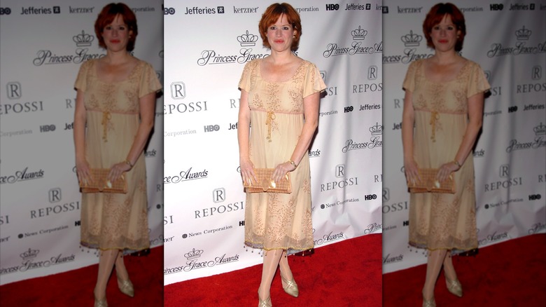 Molly Ringwald smiles in a biege dress on the red carpet