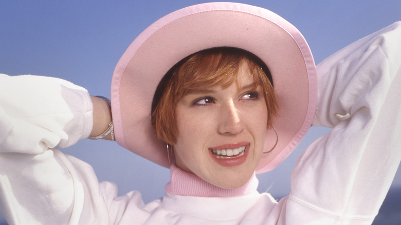 Molly Ringwald posing with her hands behind her head