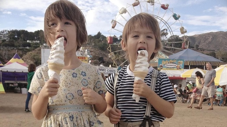 Adele and Roman Gianopoulos as toddlers eating ice cream at fun fair