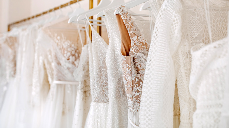 Many wedding dresses hanging in a show room