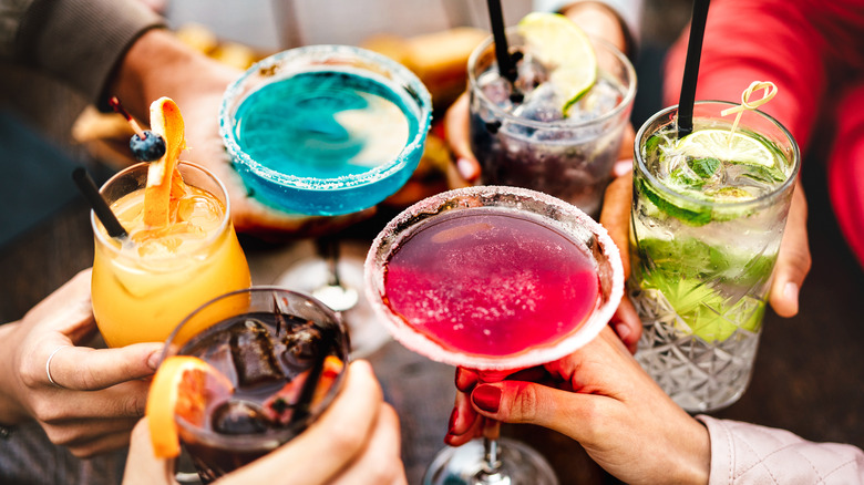 Group of people cheers their cocktails at a restaurant