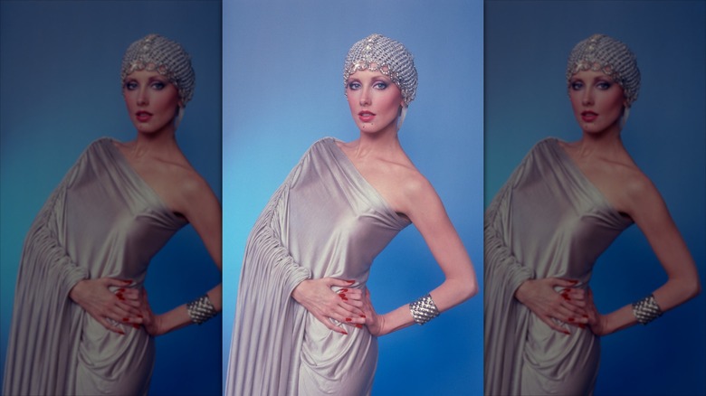 Morgan Fairchild in a silver, asymmetrical draping gown with a matching bedazzled hair cap