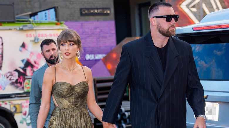 Taylor Swift and Travis Kelce walking while holding hands