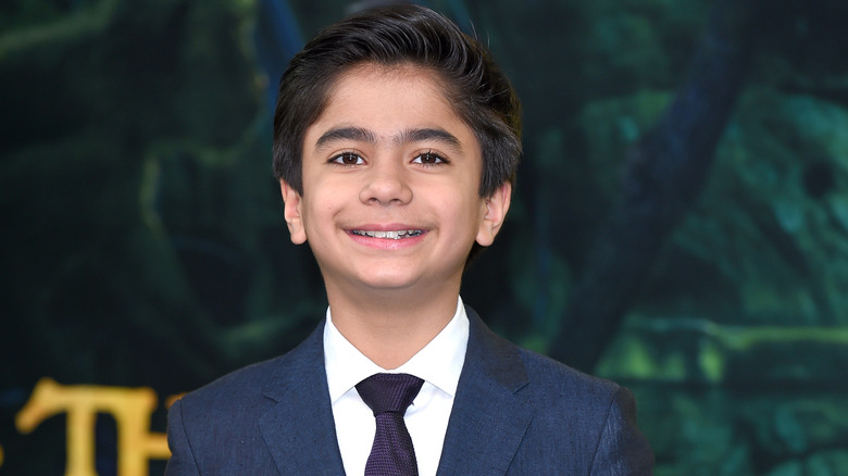 Neel Sethi smiling in navy suit