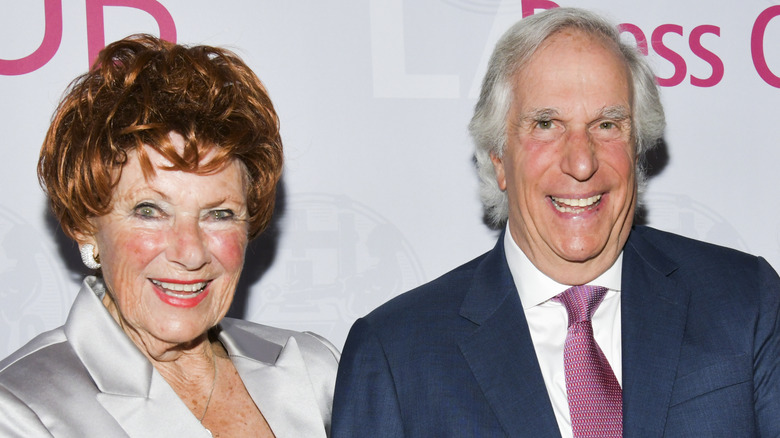 Henry Winkler and Marion Ross smiling widely while posing at an event together