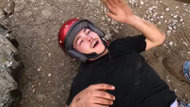 Shain Gandee laying on the ground in a red helmet