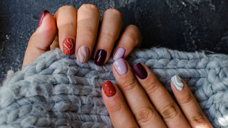 Fall-painted nails against cozy blanket