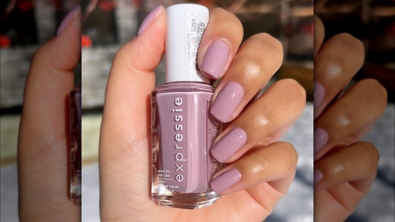 hand holding mauve nail polish bottle