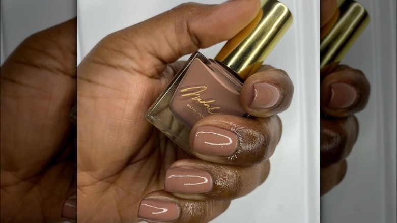 hand holding brown polish bottle