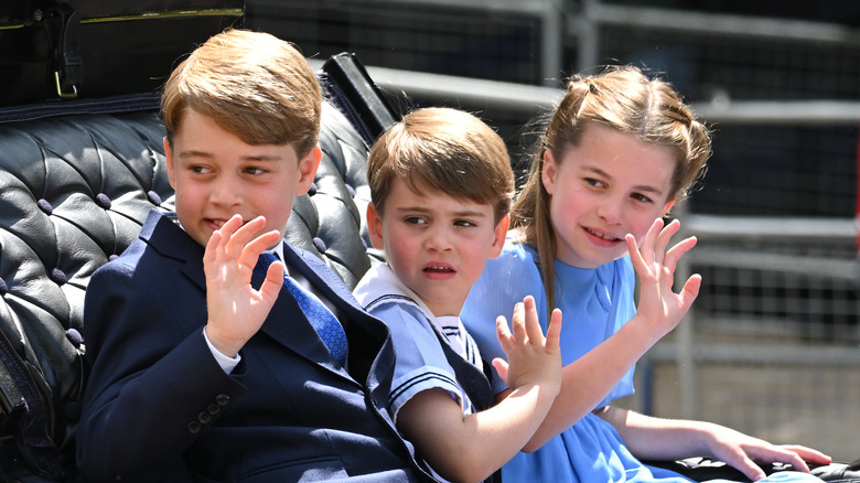 Prince George, Prince Louis, and Princess Charlotte wave from an open-top carriage