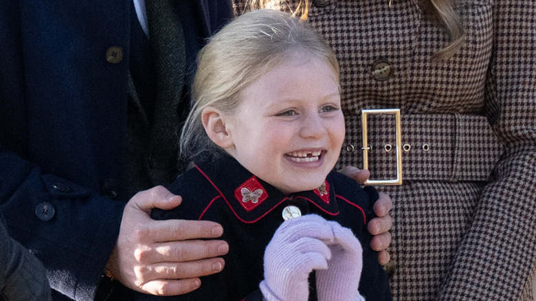 Lena Tindall smiles excitedly while wearing a coat and gloves