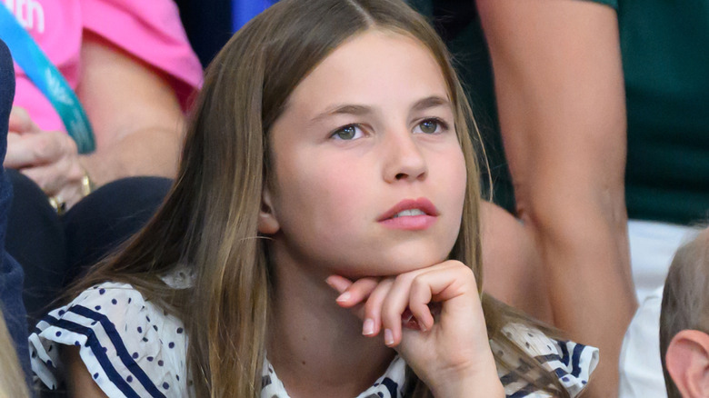 Princess Charlotte rests her head on her hand as she watches sports
