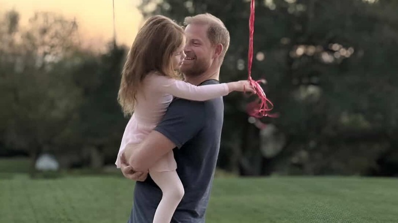 Prince Harry holding Princess Lilibet Diana outdoors