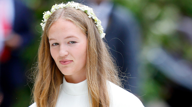 Savannah Phillips and her sister Isla Phillips carry a bride's wedding veil