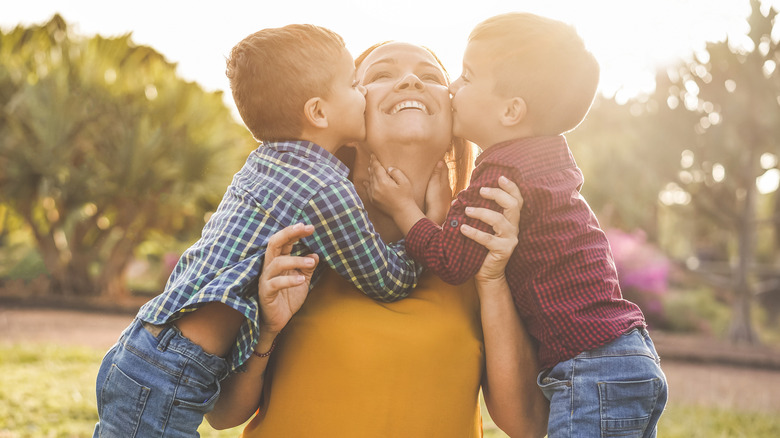 twin boys kissing their mom