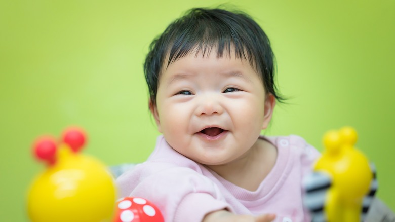 baby smiling with toys