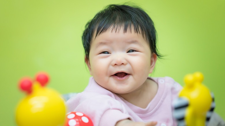 baby smiling with toys
