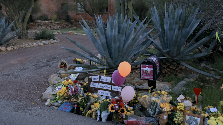 Messages and flowers from Nancy Guthrie's neighbors in front of her house