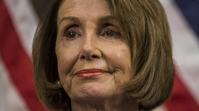 House Speaker Nancy Pelosi with slight smile wearing pearls