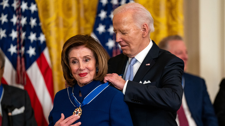 Joe Biden giving Nancy Pelosi a medal