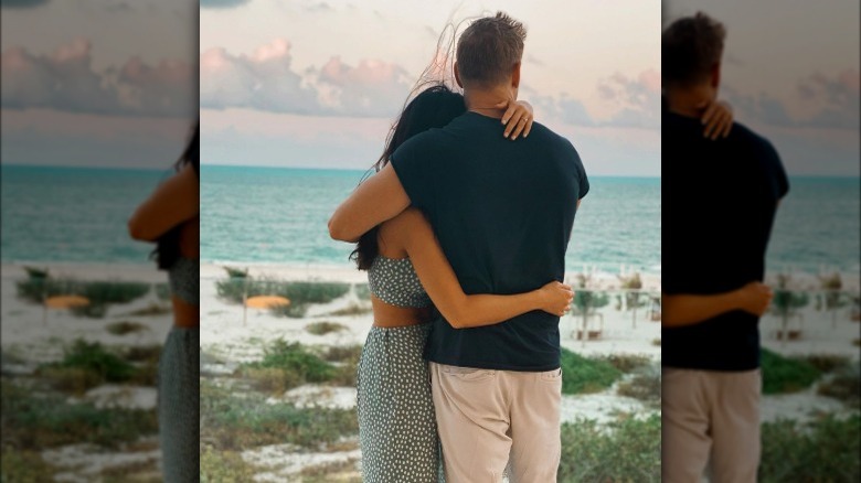 Natalie Lee and Shayne Jansen cuddling while they look out at ocean