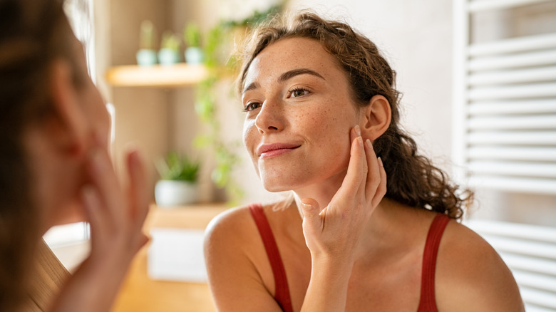 Young woman checking her face