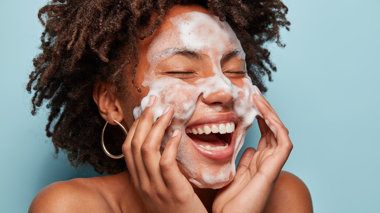 Woman cleansing face