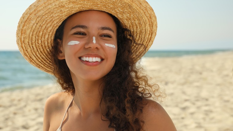 woman wearing sunblock and straw hat