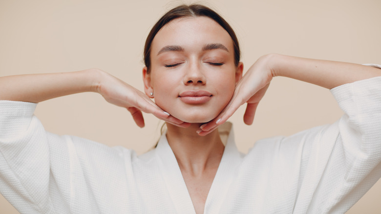 woman massaging her jawline