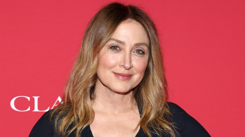 Sasha Alexander in front of red backdrop