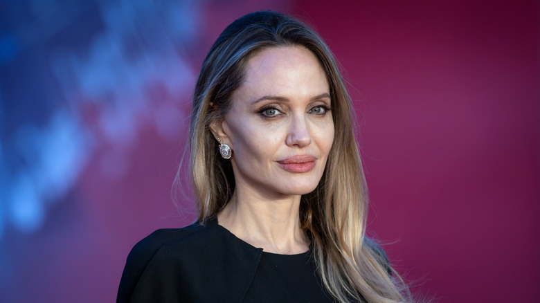 Angelina Jolie against a pink background