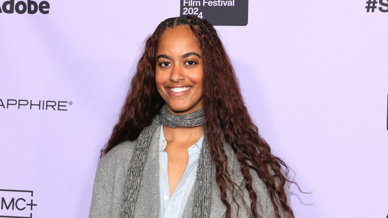 Malia Obama with long hair against purple background