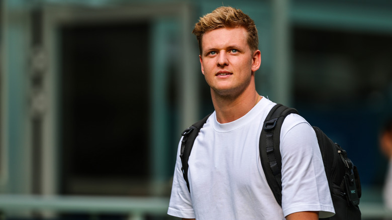 Mick Schumacher in a plain white tshirt and backpack