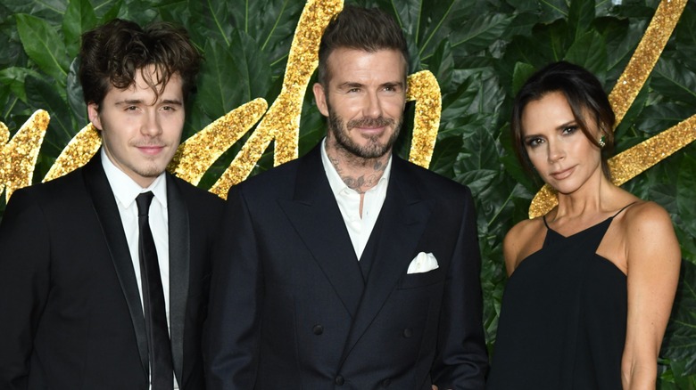 Brooklyn Beckham, David Beckham, and Victoria Beckham on a red carpet together