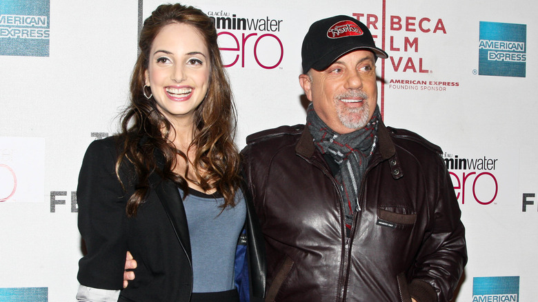 Alexa Ray Joel in black blazer smiling with dad Billy Joel