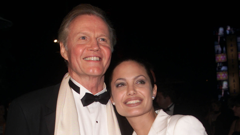 Angelina Jolie and Jon Voight smiling while posing together