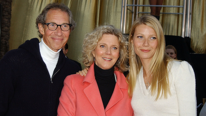 Gwyneth Paltrow smiling while posing alongside Blythe Danner and Bruce Paltrow