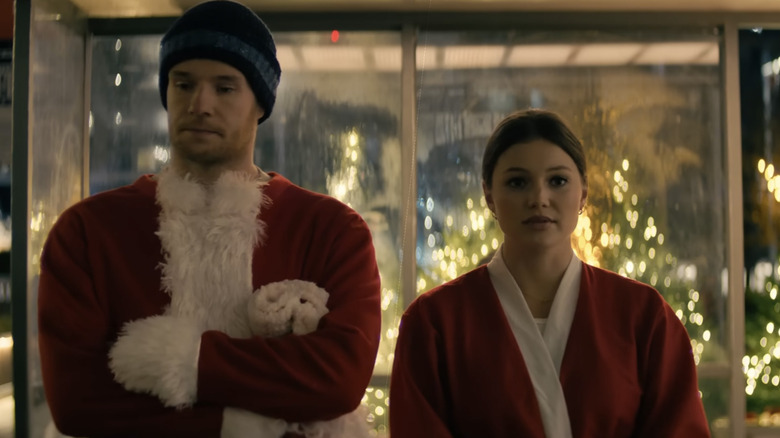 "Jingle Bell Heist" characters Sophia (Olivia Holt) and Nick (Connor Swindells) in Santa suits