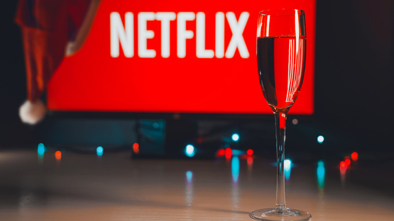 A Netflix screen surrounded by holiday lights, hats, and drinks