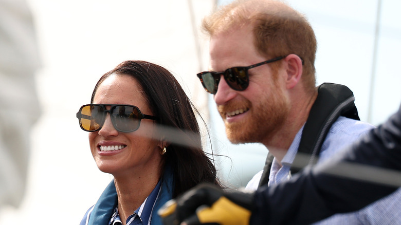Prince Harry and Meghan Markle smiling and wearing sunglasses