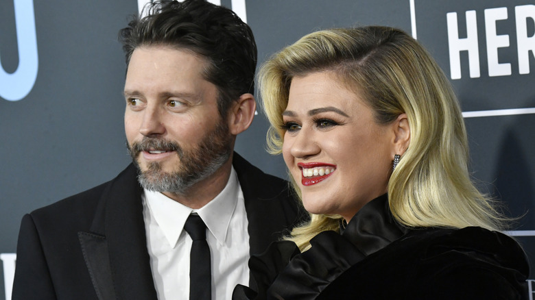 Kelly Clarkson smiling with Brandon Blackstock on the red carpet