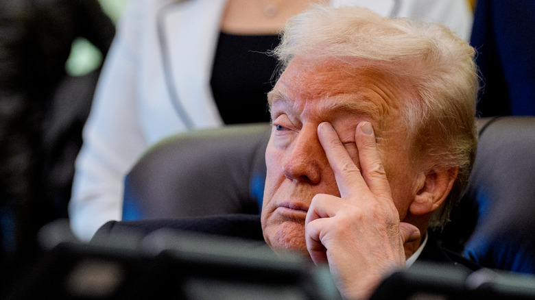Donald Trump holding his hand to his head during an Oval Office meeting
