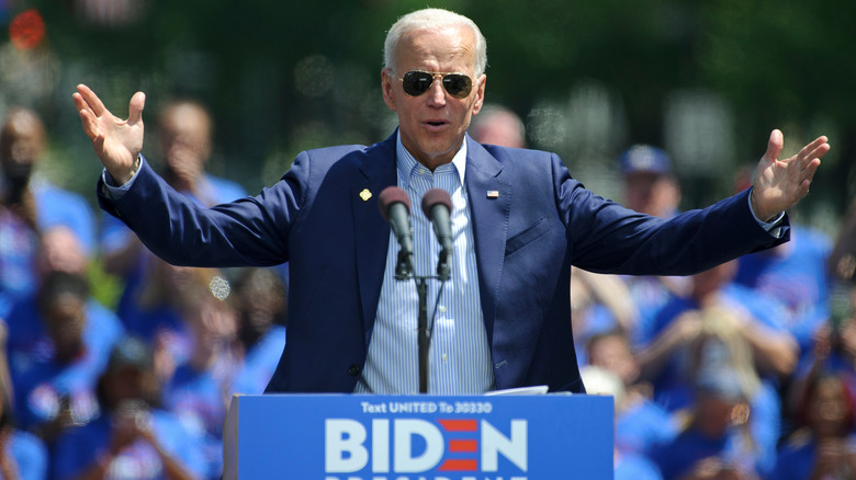 President Joe Biden speaks with sunglasses on